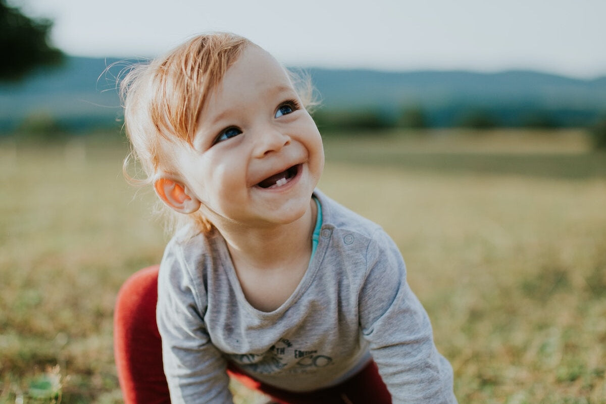 photo of baby crawling on grass