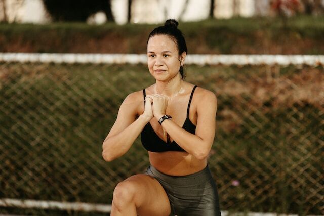 Woman in workout gear kneeling while working out