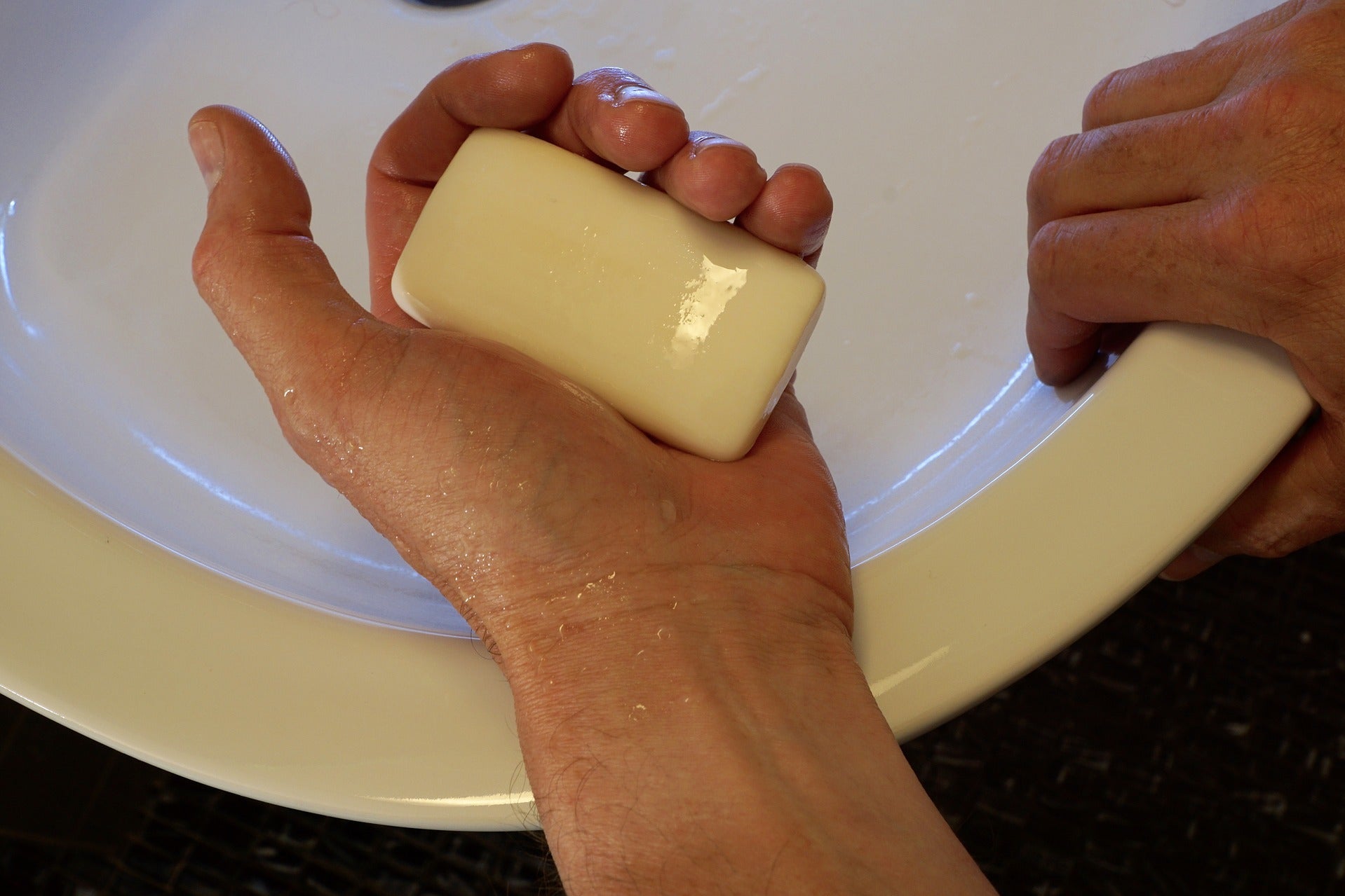 Person holding bar soap over sink